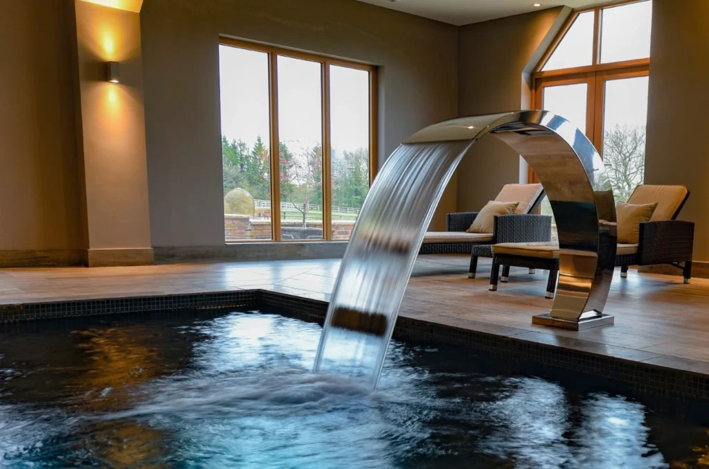 Modern spa pool with curved waterfall feature and lounge seating