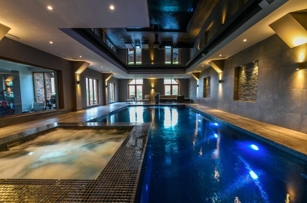 Luxury indoor swimming pool with hot tub and ambient lighting