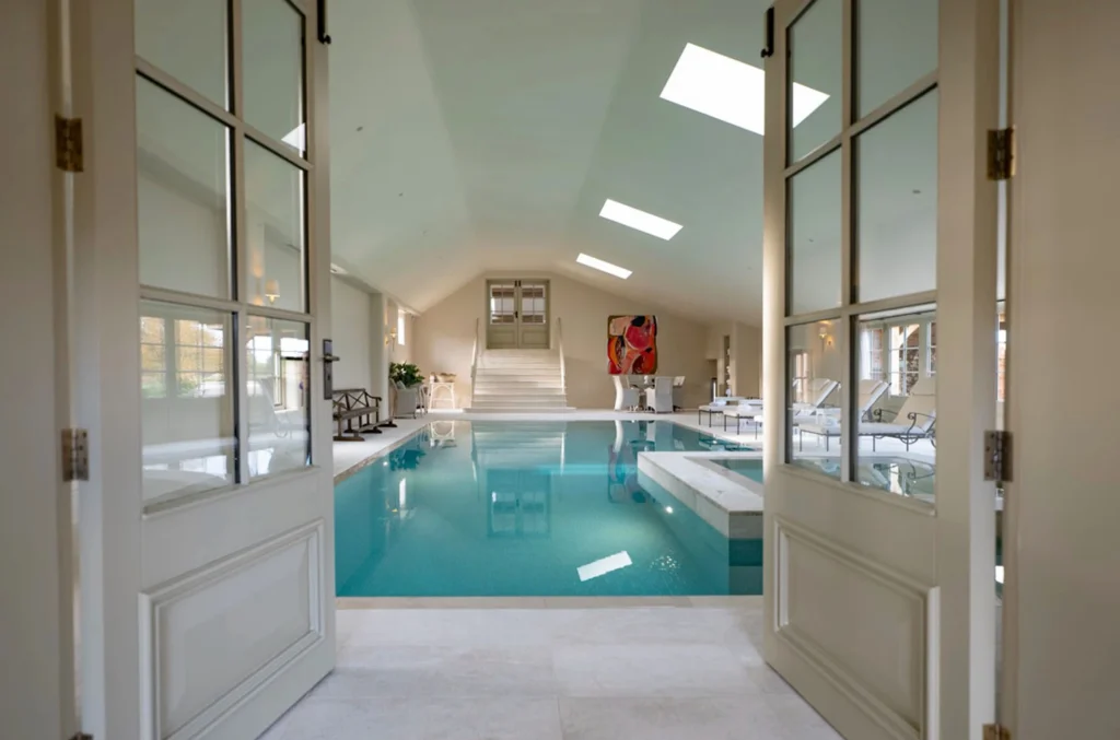 Luxurious indoor swimming pool with skylight, turquoise water