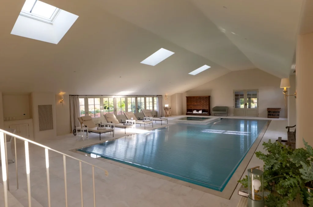 Luxurious indoor swimming pool with skylights and lounge area