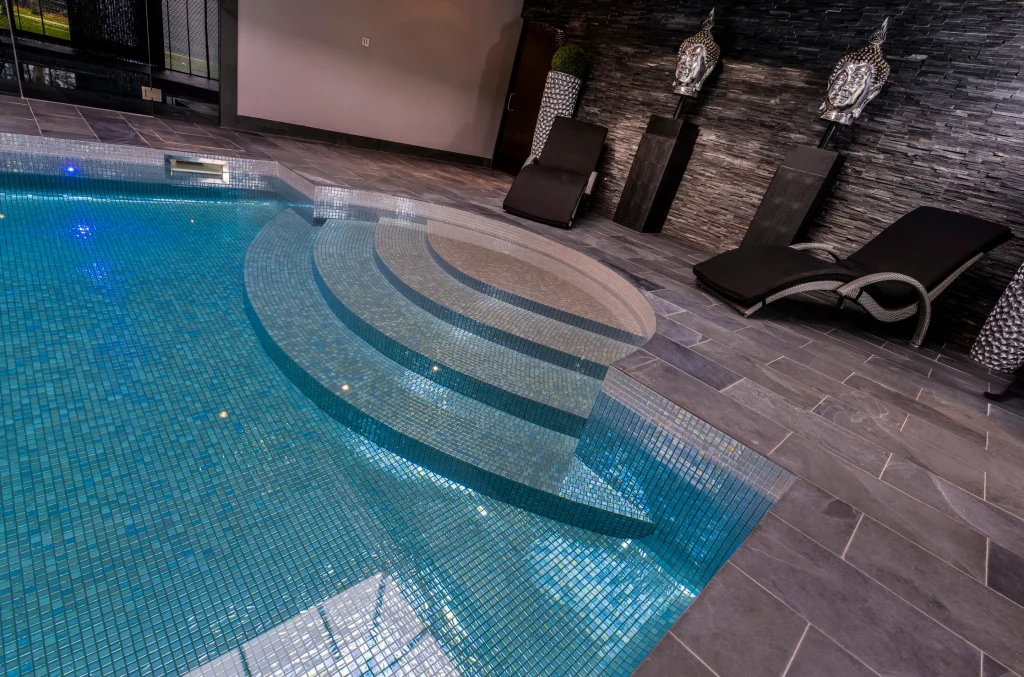 Modern indoor swimming pool with loungers and decorative wall art