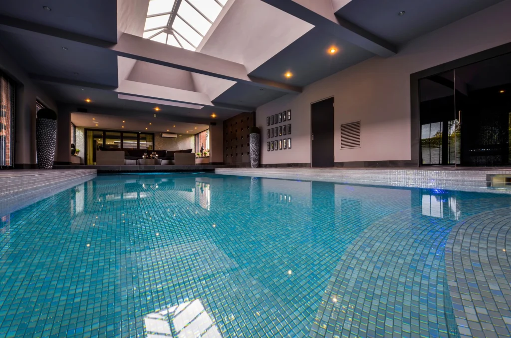 Luxurious indoor swimming pool with turquoise tiles and skylights