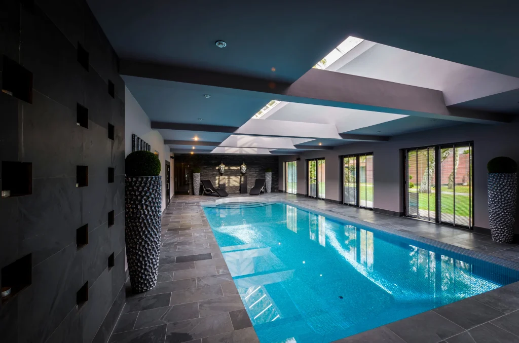 Modern indoor swimming pool with skylights and glass doors