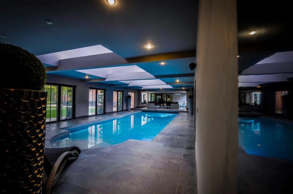 Modern indoor swimming pool with blue water and contemporary lighting