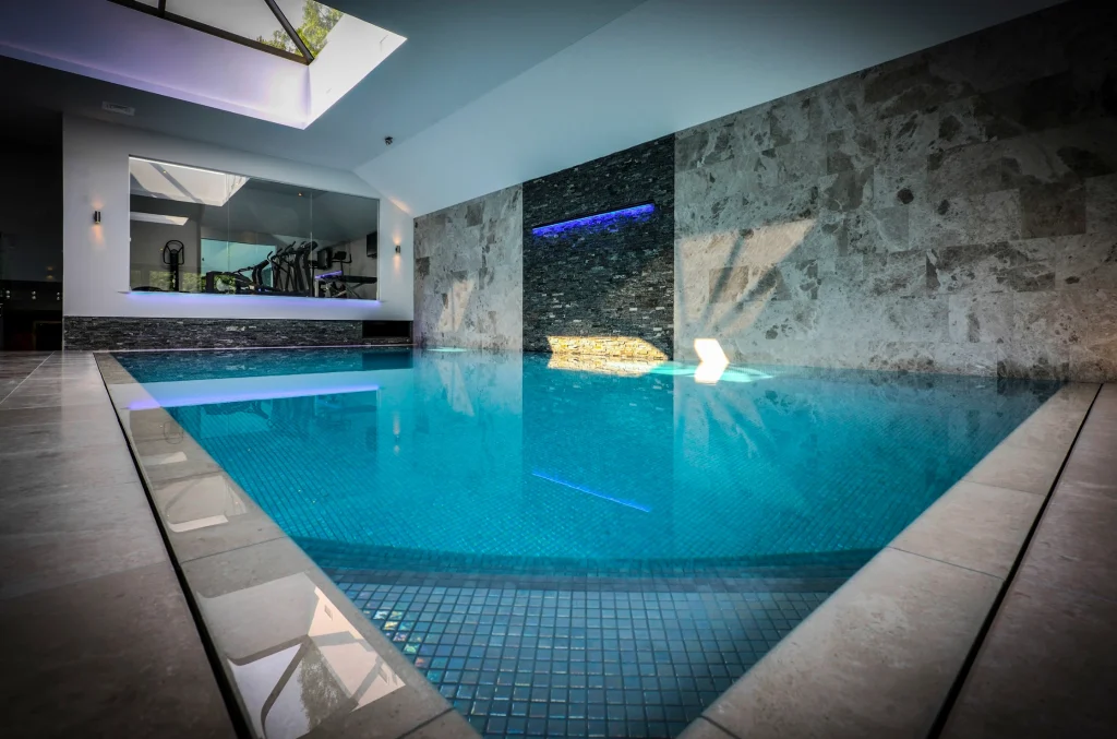 Modern indoor swimming pool with turquoise water and blue lighting