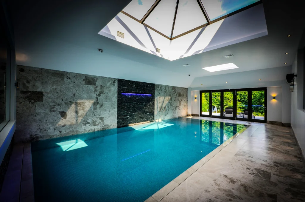 Modern indoor swimming pool with turquoise water and skylights
