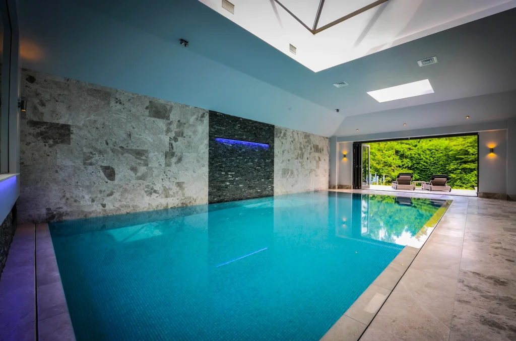 Luxurious indoor swimming pool with turquoise water and stone walls