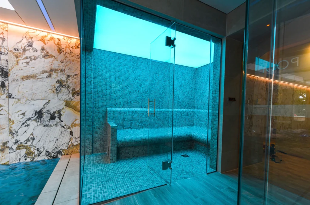Modern luxury steam shower with turquoise mosaic tiles and glass enclosure