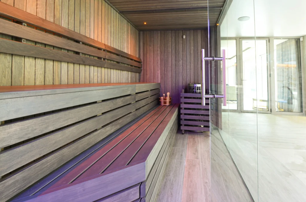Modern sauna interior with wooden benches and purple lighting