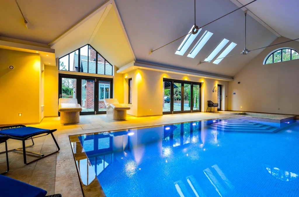Modern indoor swimming pool with bright yellow walls and skylights
