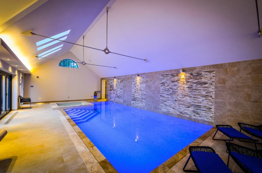 Modern indoor swimming pool with blue water and ambient lighting