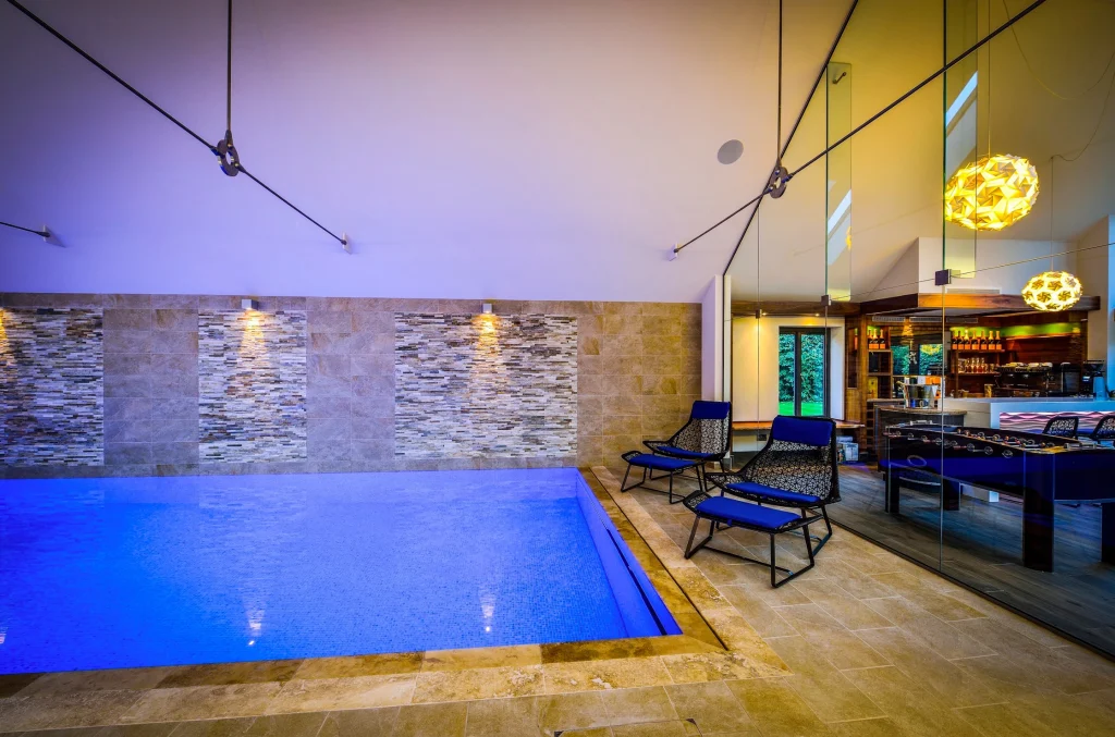 Modern indoor swimming pool with blue water and ambient lighting