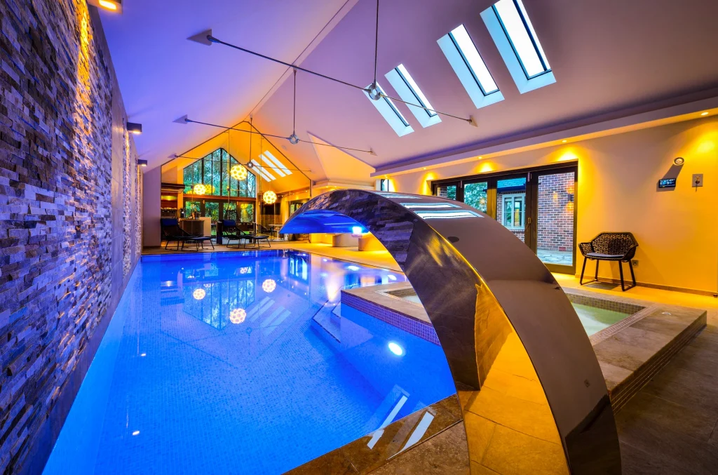 Luxury indoor swimming pool with blue lighting and yellow walls