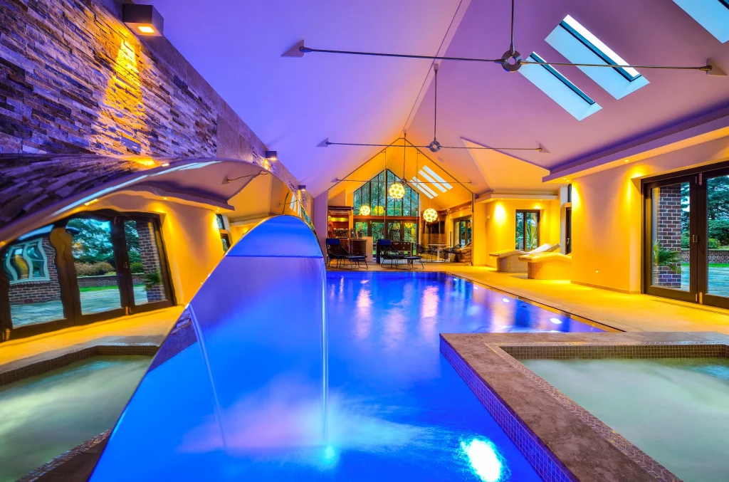 Luxury indoor swimming pool with blue water and golden lighting