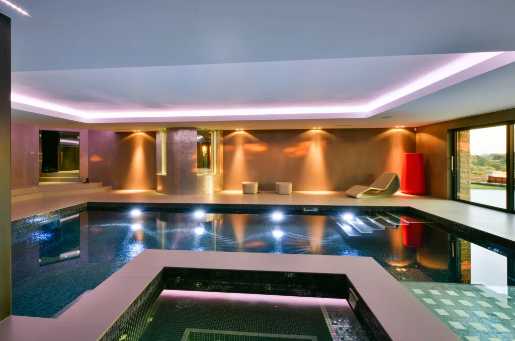 Luxurious indoor swimming pool with modern lighting and spa