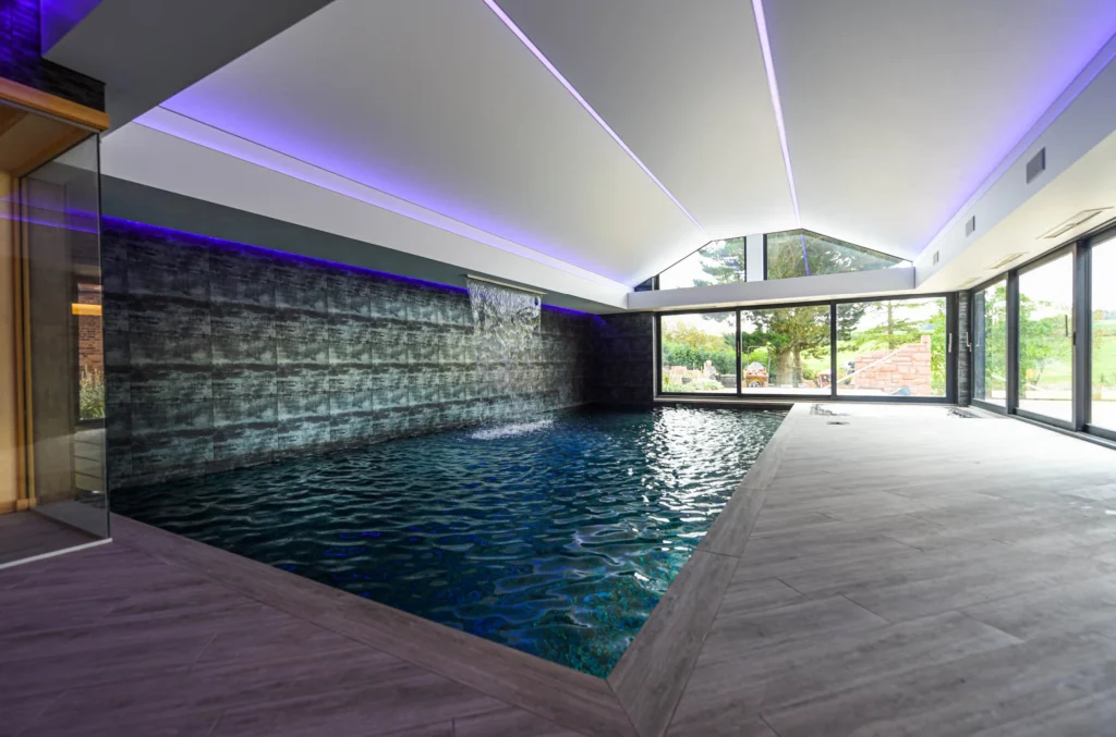 Modern indoor swimming pool with purple LED lighting