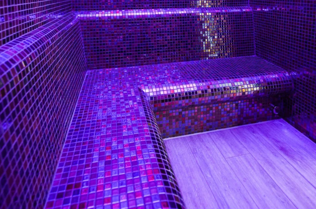 Modern spa room with vibrant purple neon mosaic tiles