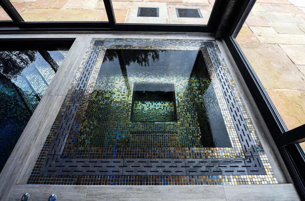 Sunken courtyard with blue mosaic tiles and glass skylight