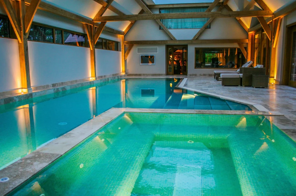 Luxurious indoor swimming pool with turquoise water and ambient lighting