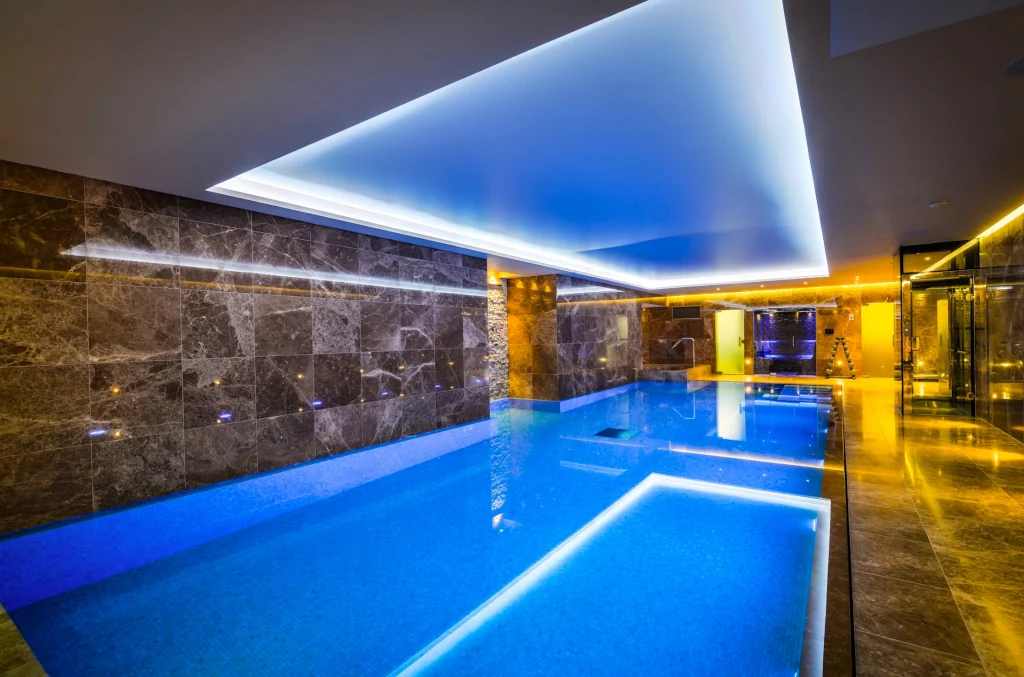 Modern luxury indoor swimming pool with blue LED lighting