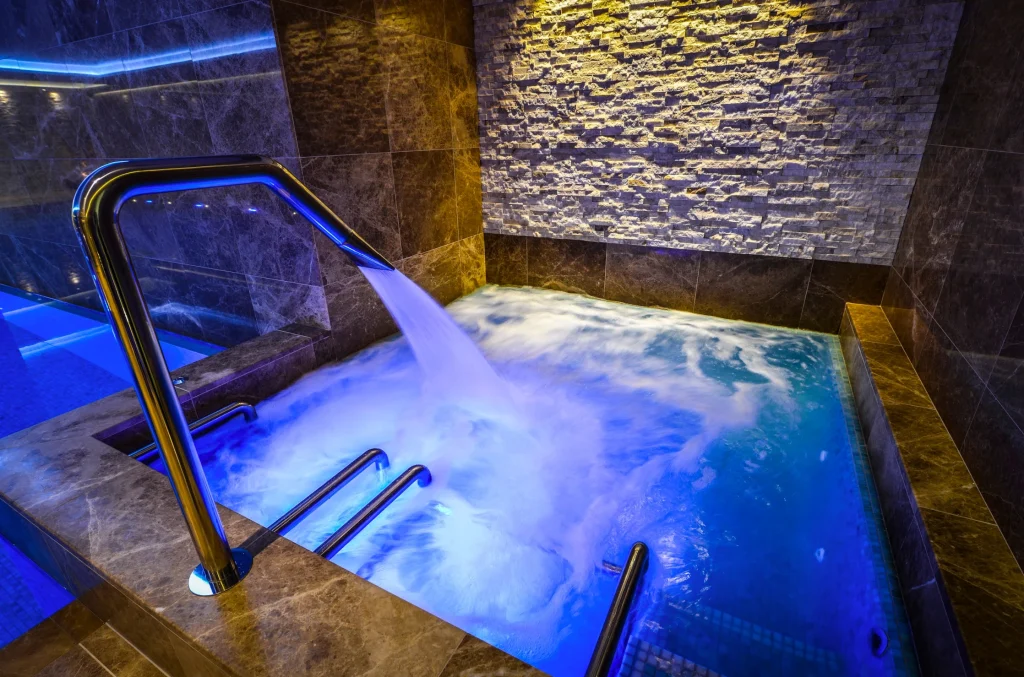 Luxurious spa bath with blue lighting and steam