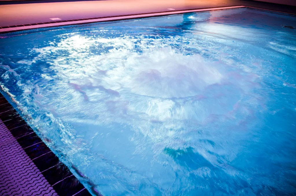 Indoor swimming pool with waves and pink sunset ceiling