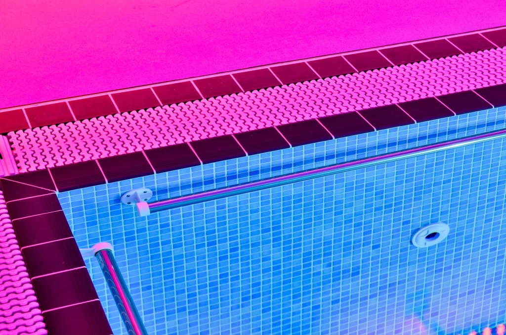 Vibrant swimming pool with pink and blue tiled interior