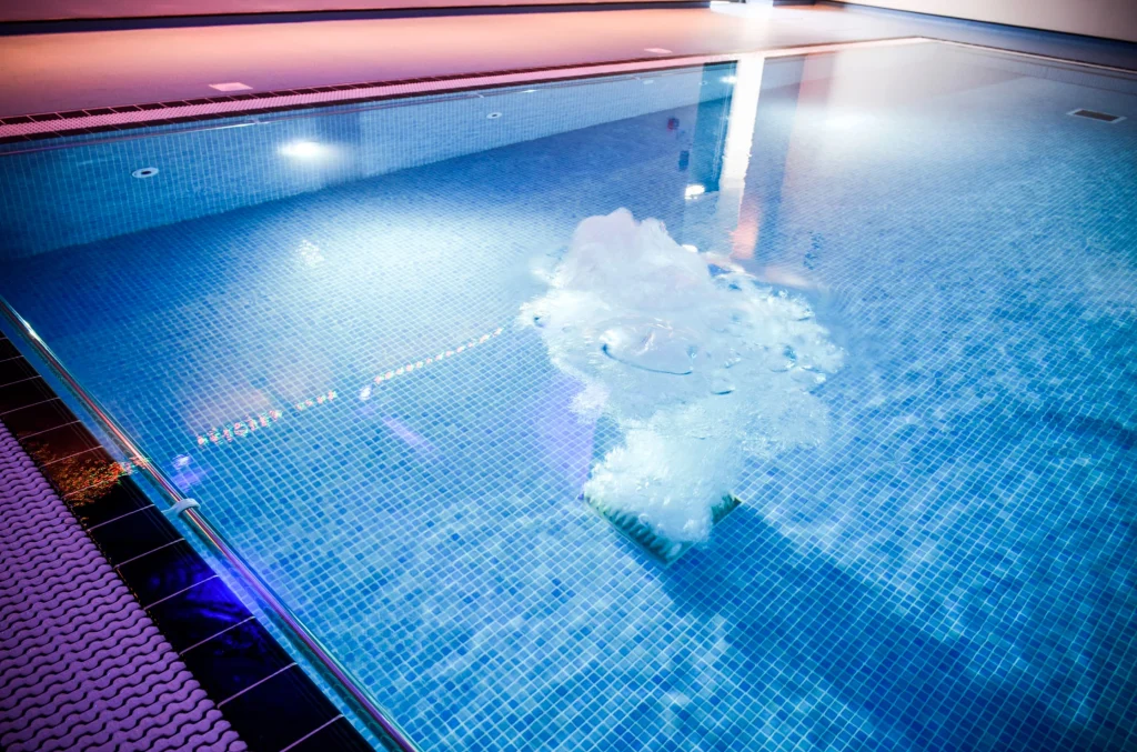Indoor swimming pool with white foam floating on blue water