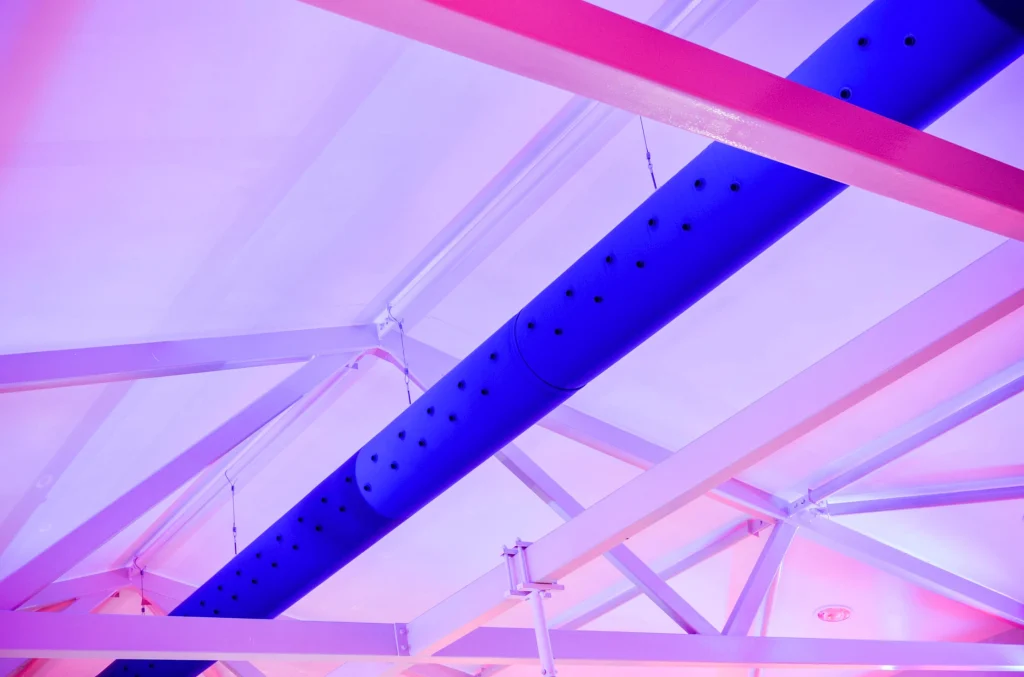 Modern ceiling with blue beam and pink geometric panels